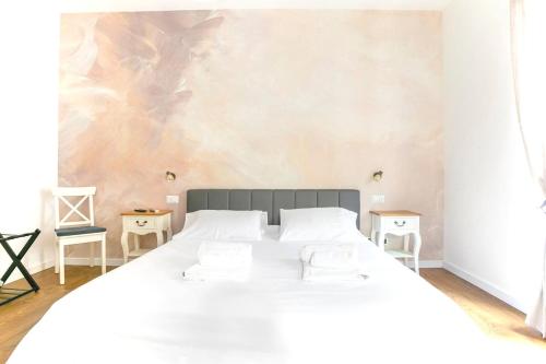 um quarto com uma grande cama branca e duas mesas em Vatican Suite Apartment - Rome City Centre em Roma