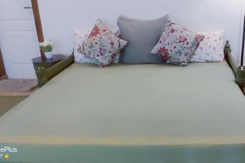 a bed with pillows on top of it at Rustic Retreat by Roamhome - Modern 2BHK Apartment near Naini Lake in Nainital