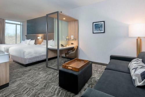 SpringHill Suites by Marriott Indianapolis Westfield في Westfield: غرفه فندقيه بسرير واريكه