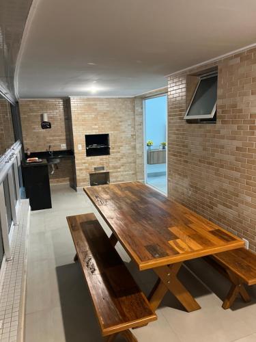 a large wooden table in a room with a kitchen at Apartamento familiar em Riviera de São Lourenço Módulo 8 in Bertioga