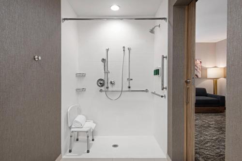 Habitación con baño con ducha y silla. en SpringHill Suites by Marriott St. George Washington, en Washington