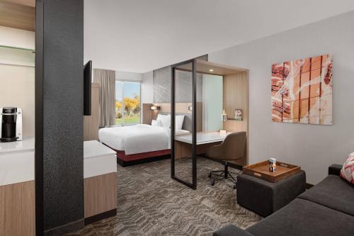 ワシントンにあるSpringHill Suites by Marriott St. George Washingtonのベッドとリビングルームが備わるホテルルームです。
