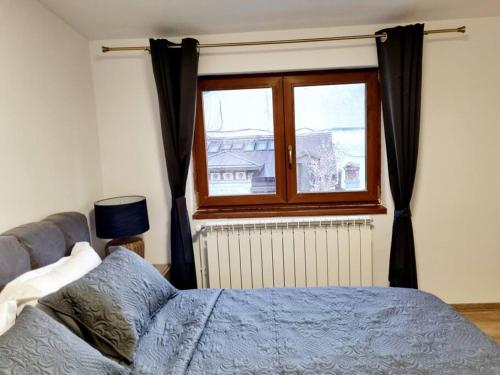 a bedroom with a bed and a window at Cozy apartment near city center in Bucharest