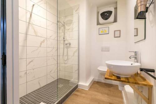 une salle de bain avec une douche en verre et un lavabo dans l'établissement Le Lemon : au coeur du centre historique, à Dijon