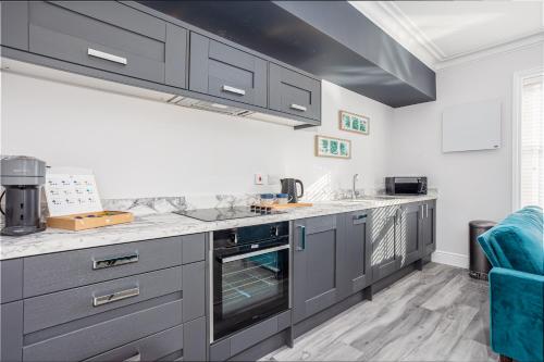 a kitchen with gray cabinets and an oven at Coppergate Mews Grimsby No7 - 2 bed, 2 bath, 1st floor apartment in Grimsby