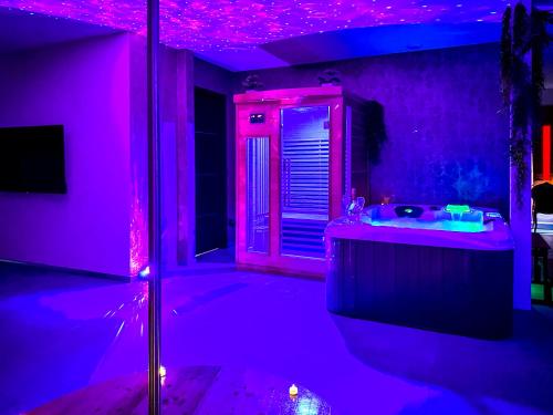 - une salle de bains pourpre avec lavabo et miroir dans l'établissement love room Villa Des Charmes-34450 vias, à Vias