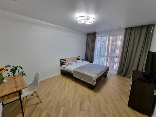 Schlafzimmer mit einem Bett, einem Schreibtisch und einem Fenster in der Unterkunft Яровиця Люкс in Luzk