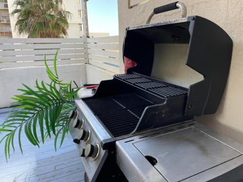 - un barbecue installé sur le côté du bâtiment dans l'établissement דירת סטודיו יפיפיה על גג ומרפסת שמש ברחוב הירקון, à Tel Aviv
