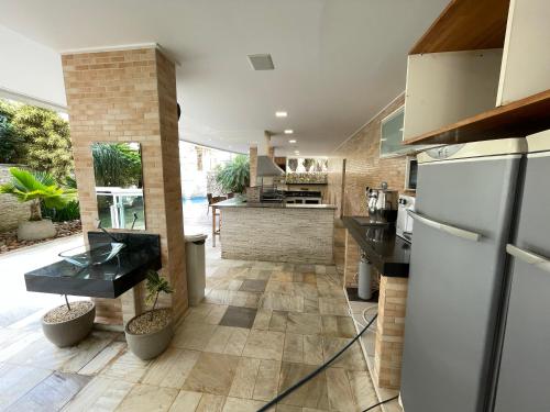 a kitchen with a refrigerator and a counter at Apartamento familiar em Riviera de São Lourenço Módulo 8 in Bertioga