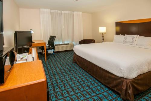 a hotel room with a bed and a flat screen tv at Fairfield Inn & Suites by Marriott San Antonio North/Stone Oak in San Antonio