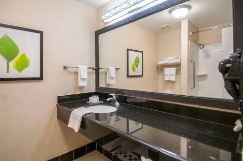 La salle de bains est pourvue d'un lavabo et d'un grand miroir. dans l'établissement Fairfield Inn & Suites by Marriott San Antonio North/Stone Oak, à San Antonio