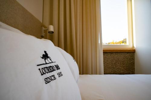 a hotel room with a pillow with a sign on it at Loureiro B&B in São Pedro do Sul
