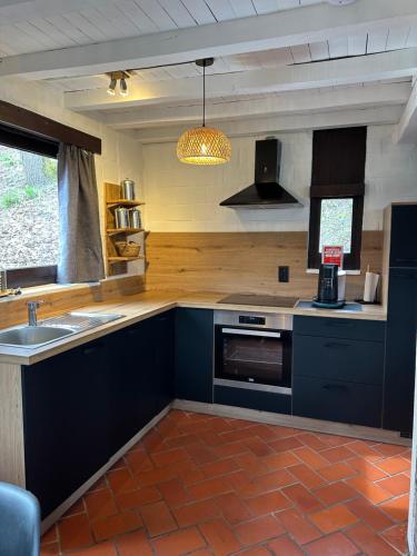 eine Küche mit blauen Schränken und einem Waschbecken in der Unterkunft Wood House in Blaimont