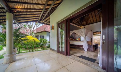 een open deur naar een kamer met een bed en een slaapkamer bij Villa Dihati in Tabanan