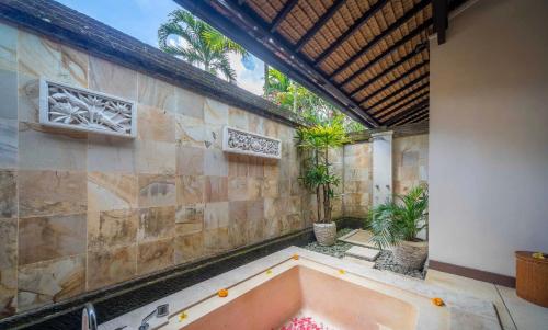 een badkamer met een bad in een gebouw bij Villa Dihati in Tabanan