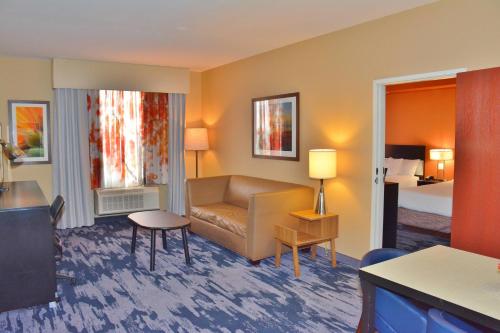 グランドジャンクショ​​ンにあるFairfield Inn & Suites by Marriott Grand Junction Downtown/Historic Main Streetのソファとベッド付きのホテルルーム