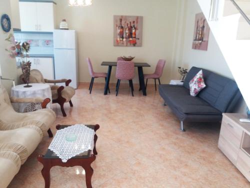 a living room with a couch and a table at Evis Maisonette with sea view in Flogita