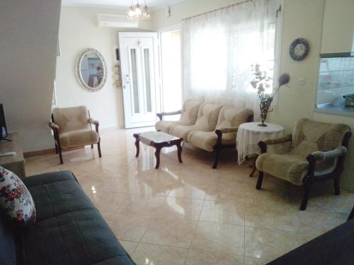 a living room with couches and chairs and a table at Evis Maisonette with sea view in Flogita