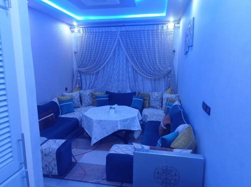 Saad apprtemnt في أغادير: غرفة معيشة مع طاولة وأريكة