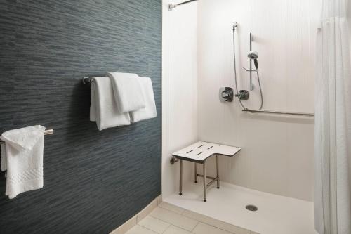 a white bathroom with a shower and a sink at Courtyard Indianapolis at the Capitol in Indianapolis