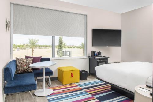 um quarto com uma cama, uma mesa e uma televisão em Aloft Glendale at Westgate em Glendale