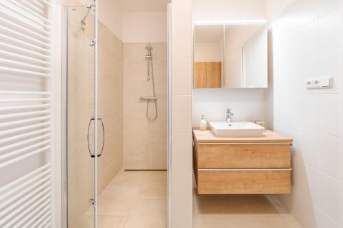 a bathroom with a sink and a shower at Deluxe Apartment Lipno - Lake Side Village, Frymburk nad Vltavou in Frymburk