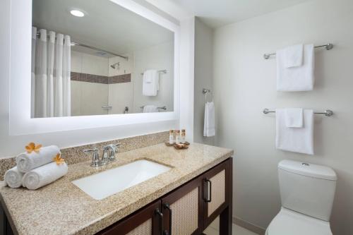 a bathroom with a sink and a toilet and a mirror at Marriott's Kaua'i Beach Club in Lihue