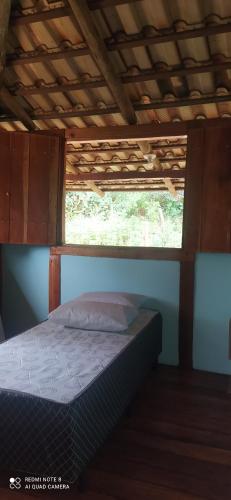 een bed in een kamer met een raam bij Sitio meu Sonho in Itatiayassú