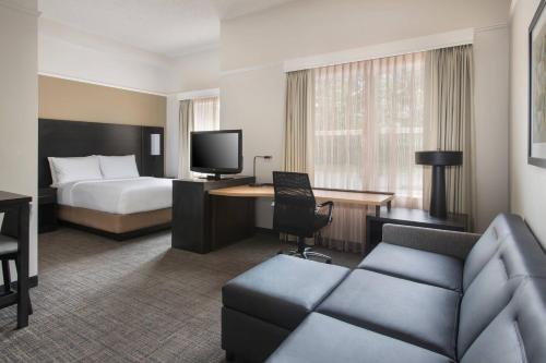 Residence Inn Silver Spring في سيلفر سبرينغ: غرفه فندقيه بسرير واريكه