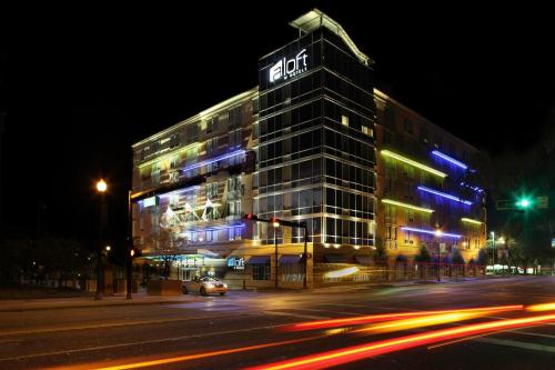 a lit up building on a city street at night at Aloft Tallahassee Downtown in Tallahassee