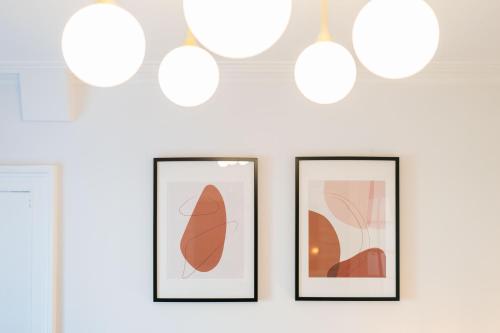 three framed pictures on a wall with lights at Seaside Home in Stonehaven, Aberdeenshire in Stonehaven