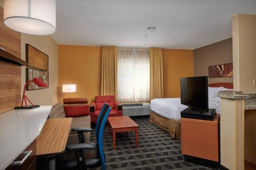 Habitación de hotel con cama y sala de estar. en TownePlace Suites Tampa North I-75 Fletcher, en Tampa