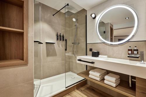 une salle de bain avec une douche, un lavabo et un miroir dans l'établissement Residence Inn by Marriott Strasbourg, à Strasbourg