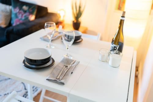 a white table with a bottle of wine and glasses at Seaside Home in Stonehaven, Aberdeenshire in Stonehaven