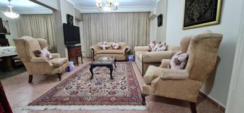 een woonkamer met stoelen en een tafel en een televisie bij Comfy 2 Bedrooms Apartment in Cairo 98-4 in Caïro