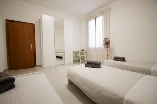 a white room with two beds and a mirror at Casa Kika - Tremezzina Lenno in Lenno