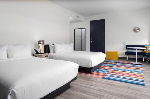 a hotel room with two beds and a desk at Aloft Savannah Airport in Savannah