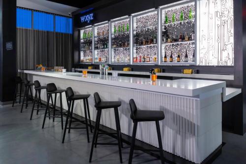a bar with a row of stools around it at Aloft Savannah Airport in Savannah