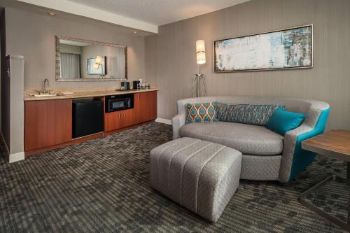 a living room with a couch and a kitchen at Courtyard by Marriott Gaithersburg Washingtonian Center in Gaithersburg