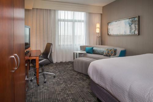 ゲイザースバーグにあるCourtyard by Marriott Gaithersburg Washingtonian Centerのベッドとソファ付きのホテルルーム