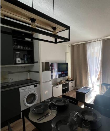 - une cuisine avec une table et de la vaisselle dans l'établissement CAP ESTEREL Appartement, à Agay