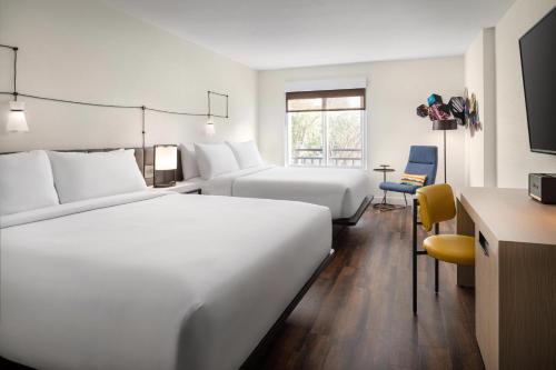 a hotel room with two beds and a desk at Aloft Mountain View in Mountain View
