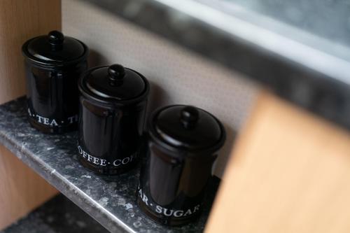 three black bottles sitting on a ledge at Seaside Home in Stonehaven, Aberdeenshire in Stonehaven