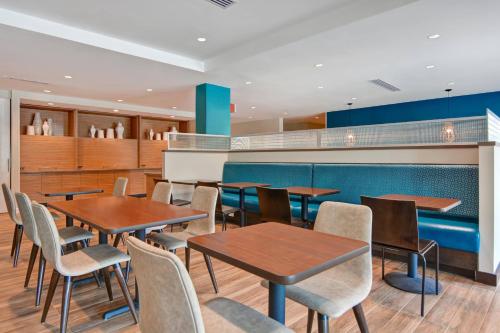 a dining room with wooden tables and chairs at TownePlace Suites by Marriott Panama City Beach Pier Park in Panama City Beach