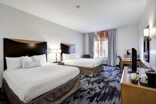 Fairfield Inn and Suites by Marriott San Antonio Boerne في بويرن: غرفة فندقية بسريرين وتلفزيون بشاشة مسطحة
