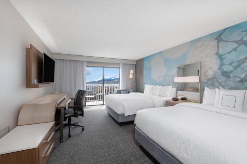 a hotel room with two beds and a desk at Courtyard by Marriott Reno in Reno