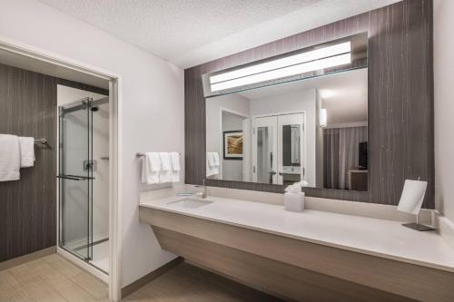 a bathroom with a sink and a mirror at Courtyard by Marriott Reno in Reno