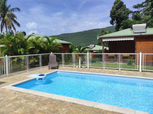 a swimming pool in front of a house at Le Tri Haut de Bellevue - Bungalow Héliconia in Pointe-Noire