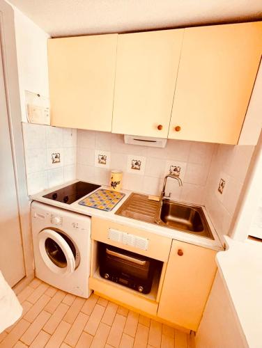 une petite cuisine avec un évier et une machine à laver dans l'établissement Studio vue mer, à Agay