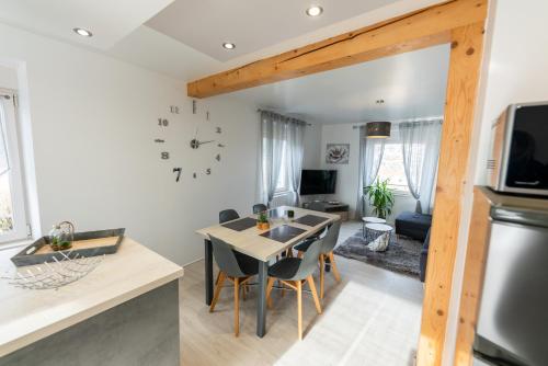 une cuisine et un salon avec une table et des chaises dans l'établissement Gîte l'Améthyste 3 appartements, à Gérardmer